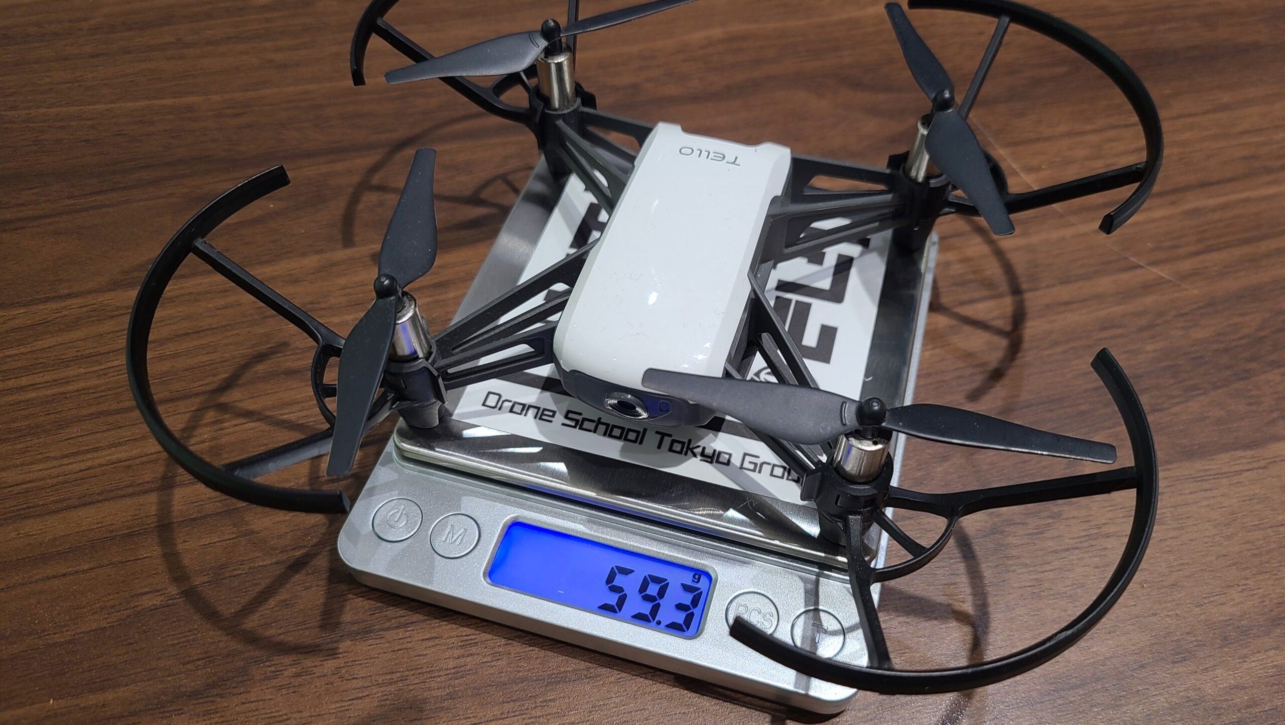 デジタルはかりに載せた小型ドローン。表示は59.3g
